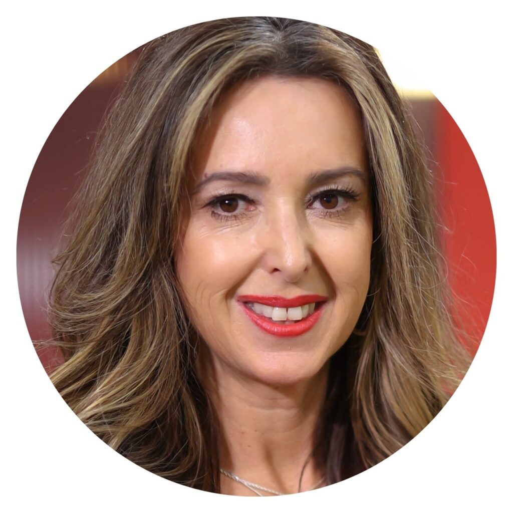Portrait of a smiling woman with wavy brown hair and red lipstick, framed in a circle.