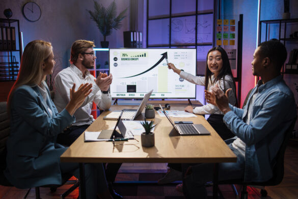 Diverse team applauds success of business concept growth chart presentation