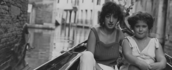 Two young women in a gondola on a Venetian canal
