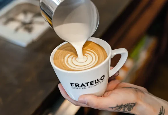 Fratello Coffee Roasters barista pouring steamed milk into a latte creating rosetta latte art