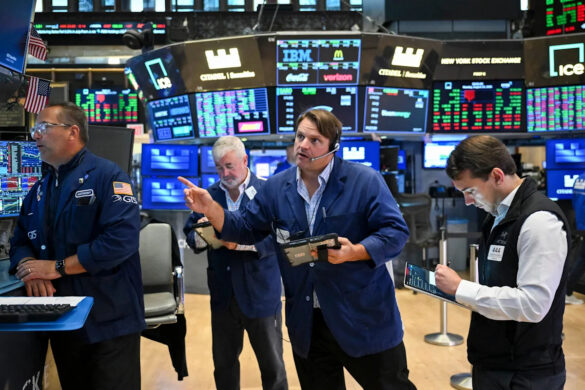 Stock market trading floor with declining indices displayed on screens