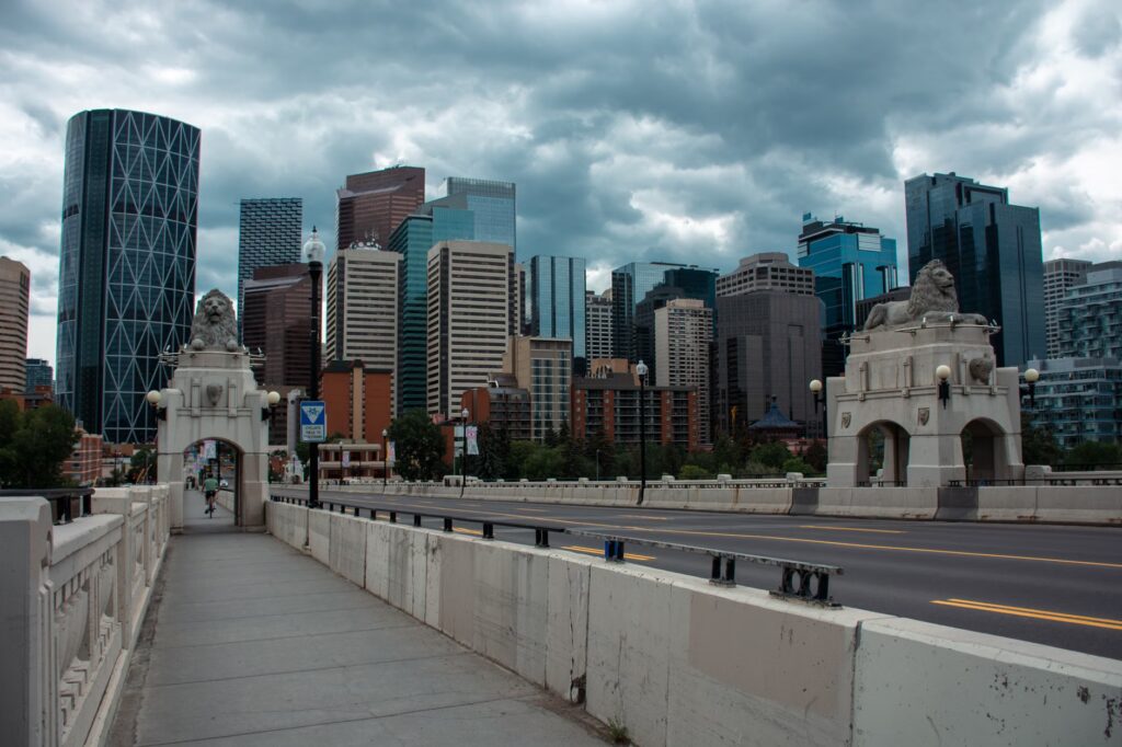 Dramatic view of Calgary's skyline with Centre Street Bridge in the foreground.