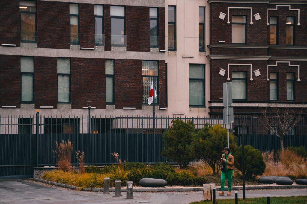 Exterior of the Japanese Embassy in Kyiv, featuring the national flag and urban landscape.